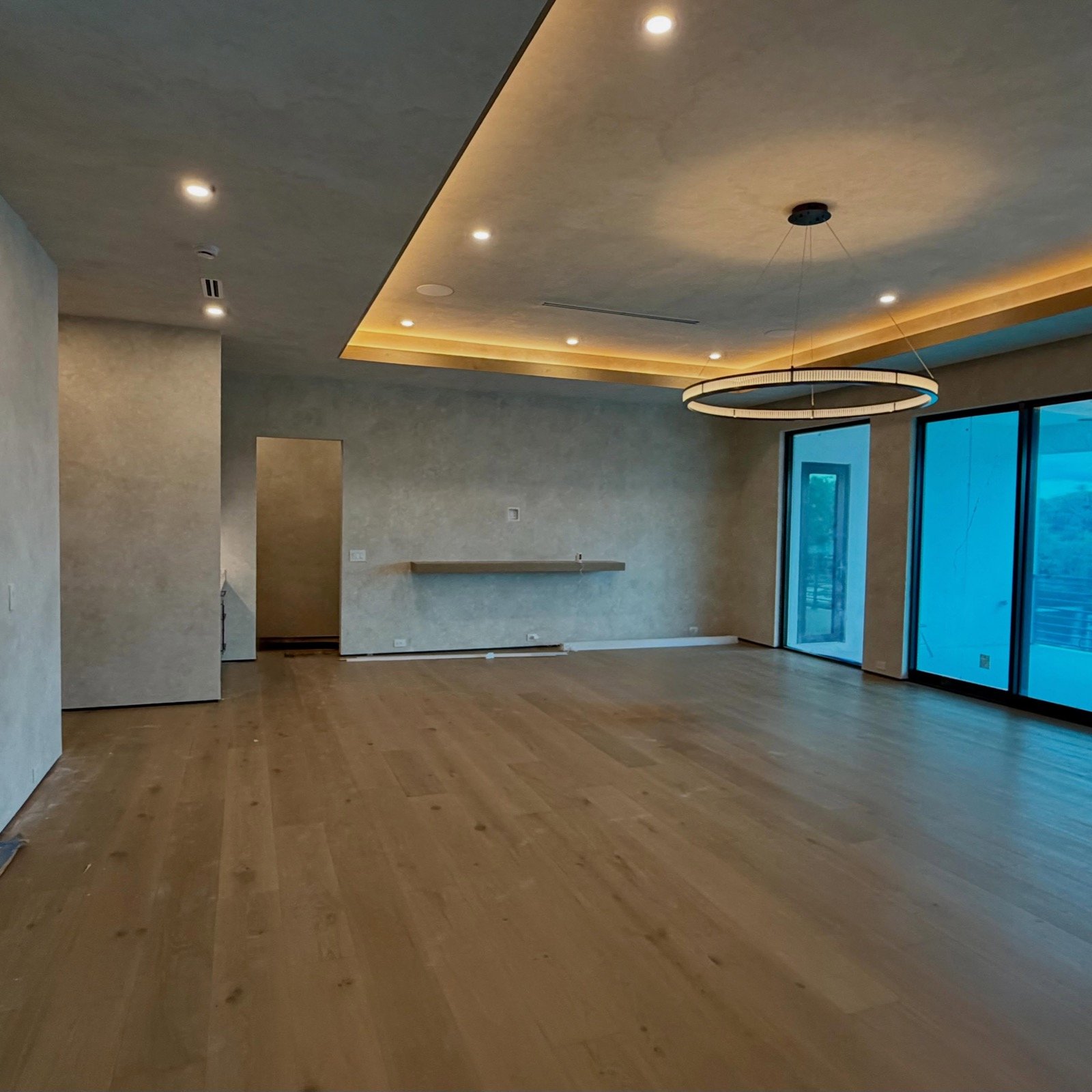 Newly finished open living space with cove lighting.
