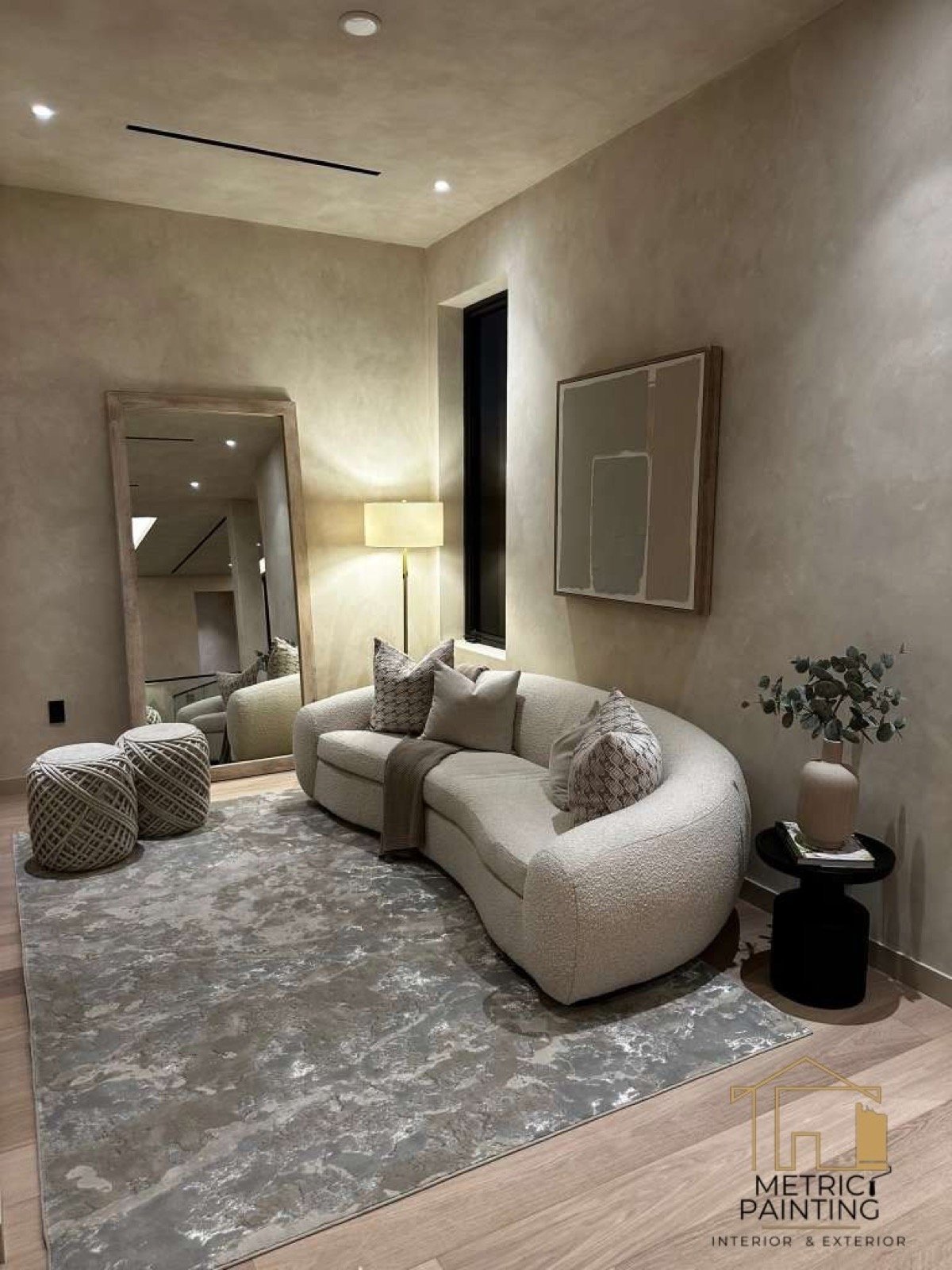 Limewash living room with a curved sofa and layered rugs.