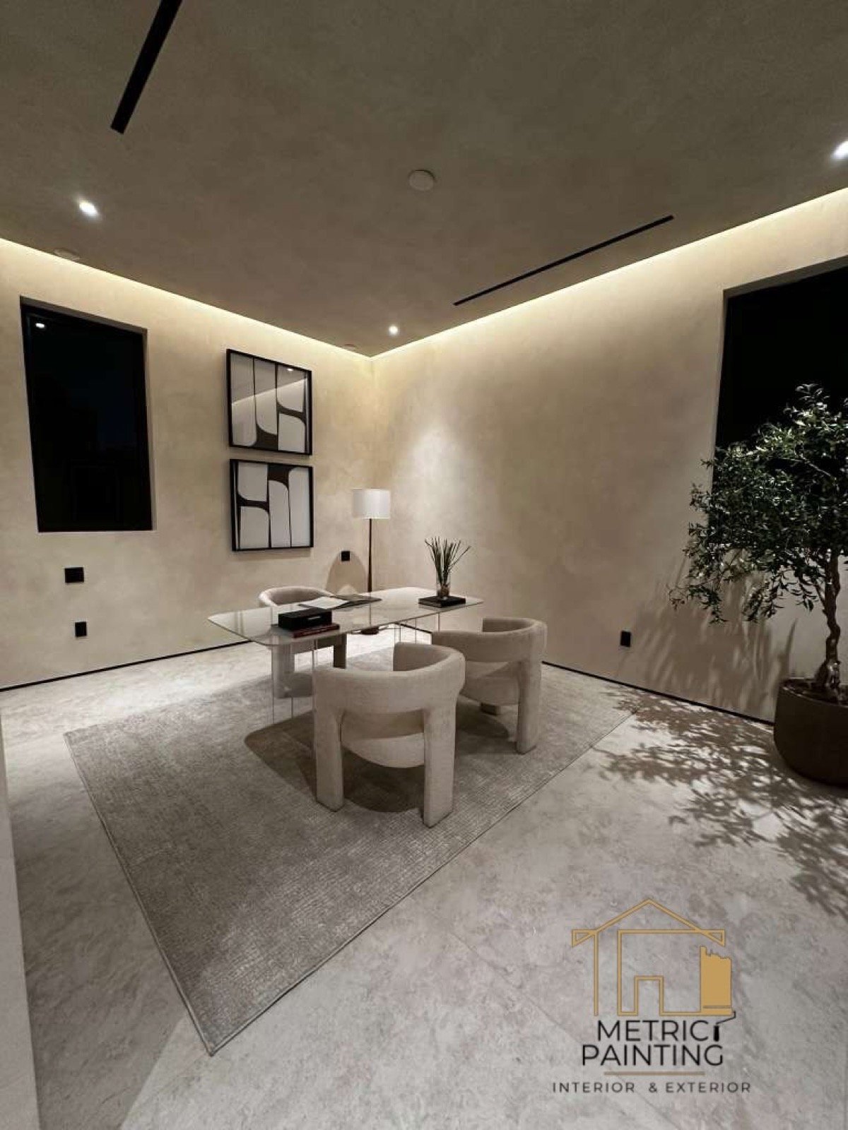 Limewash lounge with a glass table, boucle chairs, and an olive tree.